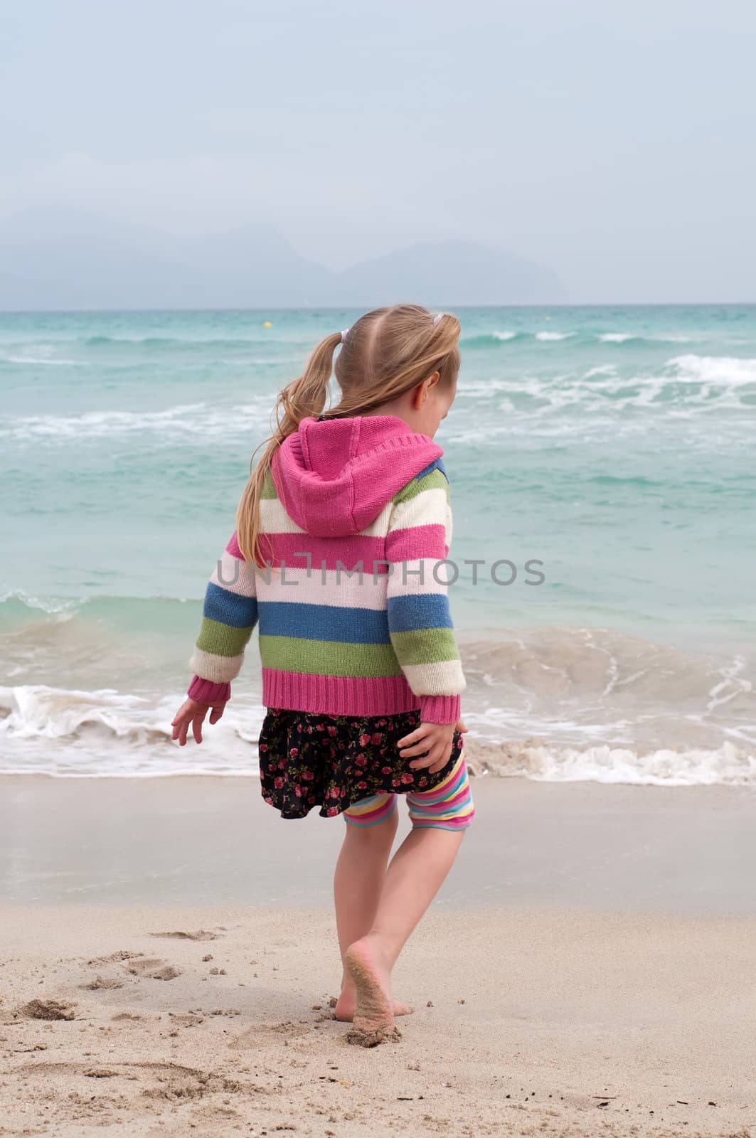 Little girl playing on the beach, sea nad sand