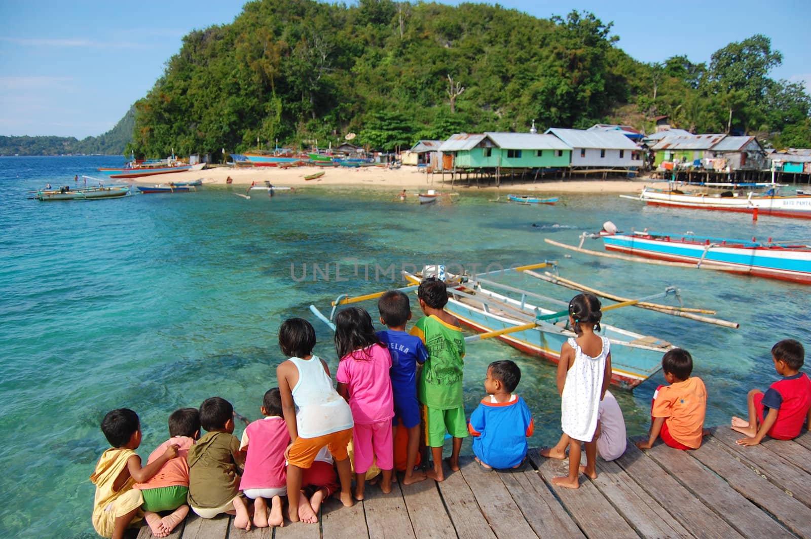Children at timber pier look to the sea, Jayapura, Indonesia