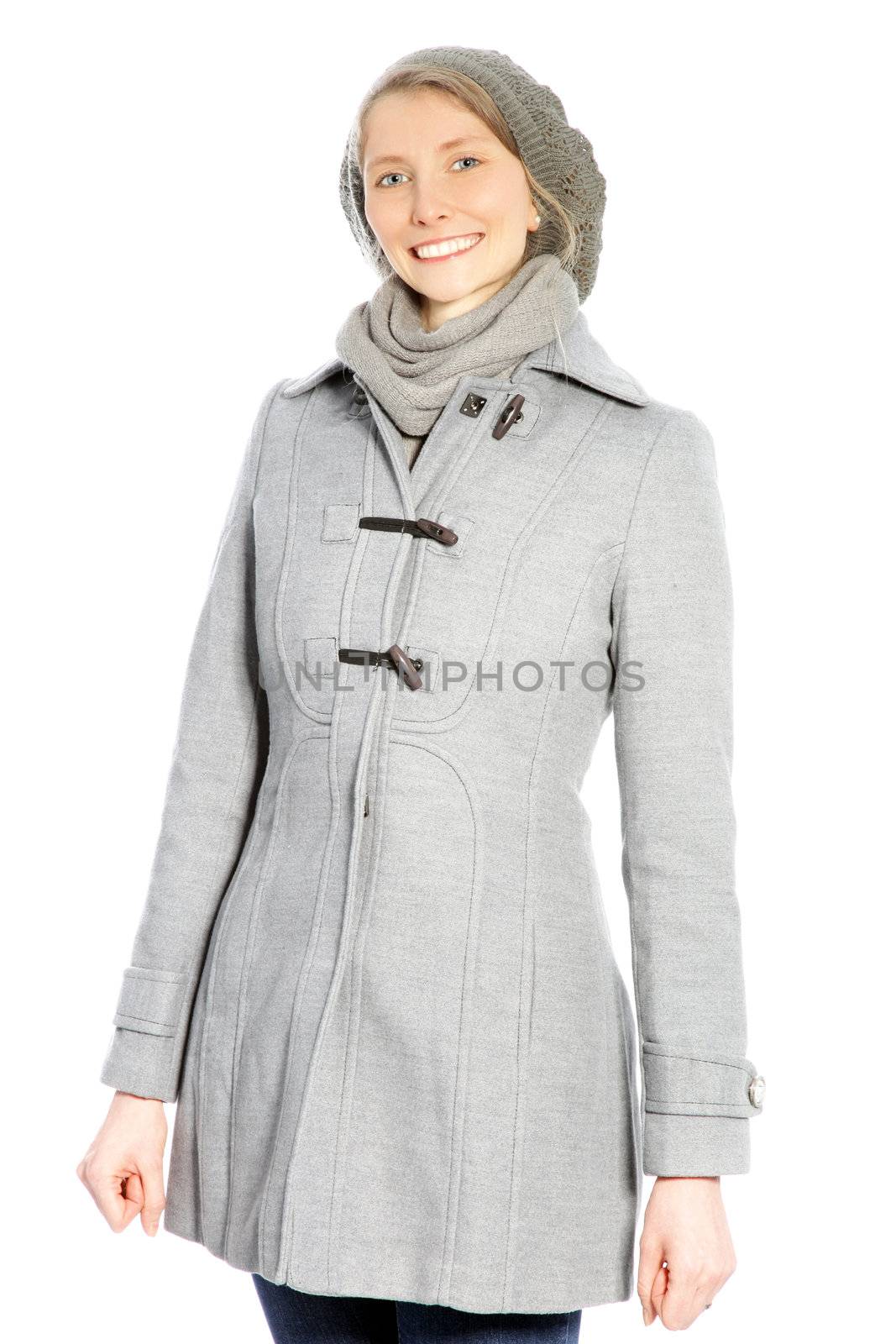 Young attractive woman wearing a grey coat and hat smiling at the camera.