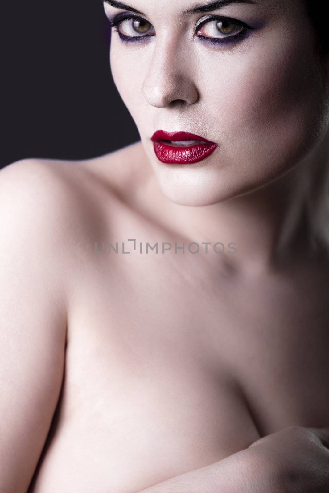 Sensual beautiful nude brunette girl over dark backdrop, caucasian woman