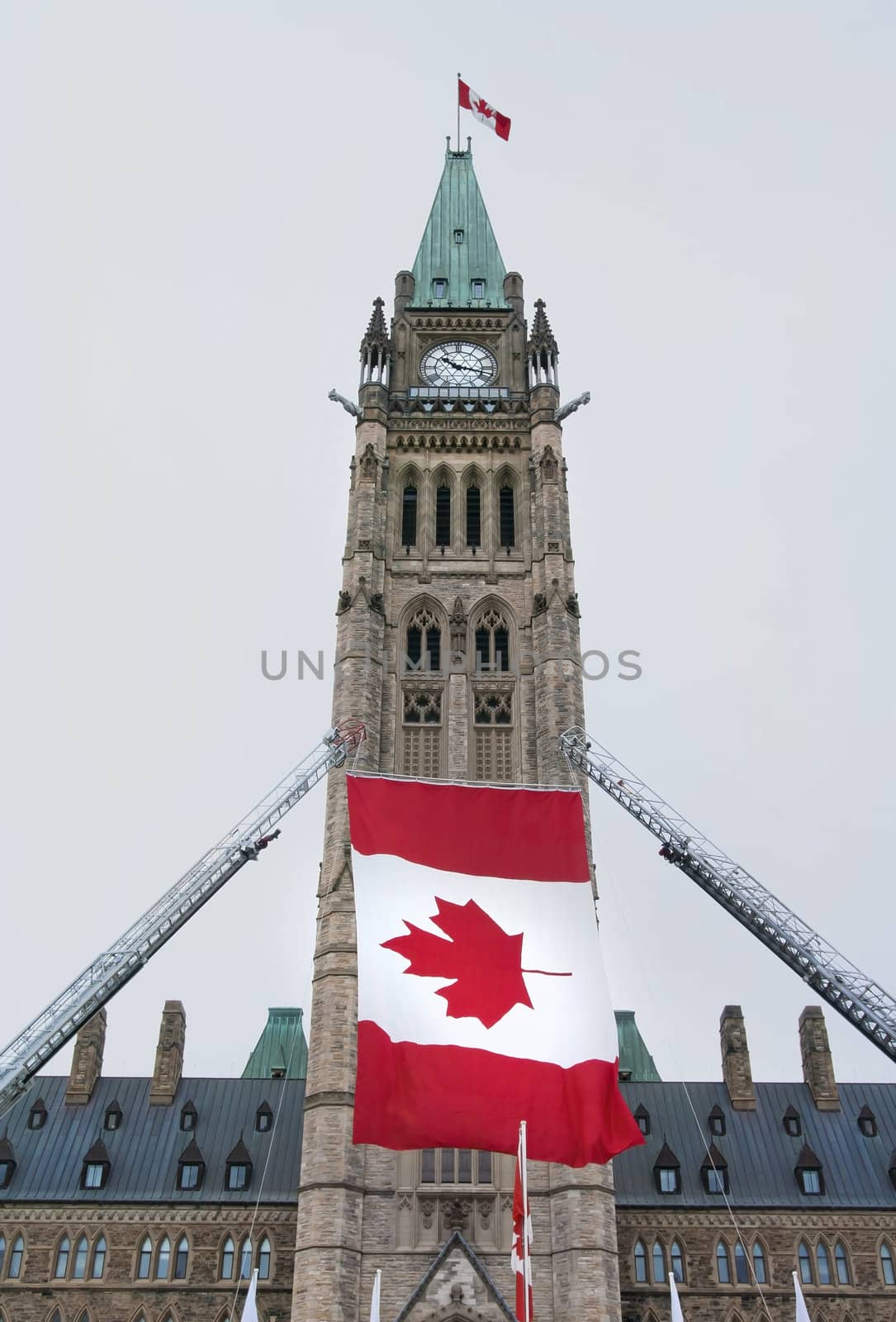 The Canadian Parliament Centre block with canadian flags during a celebration.