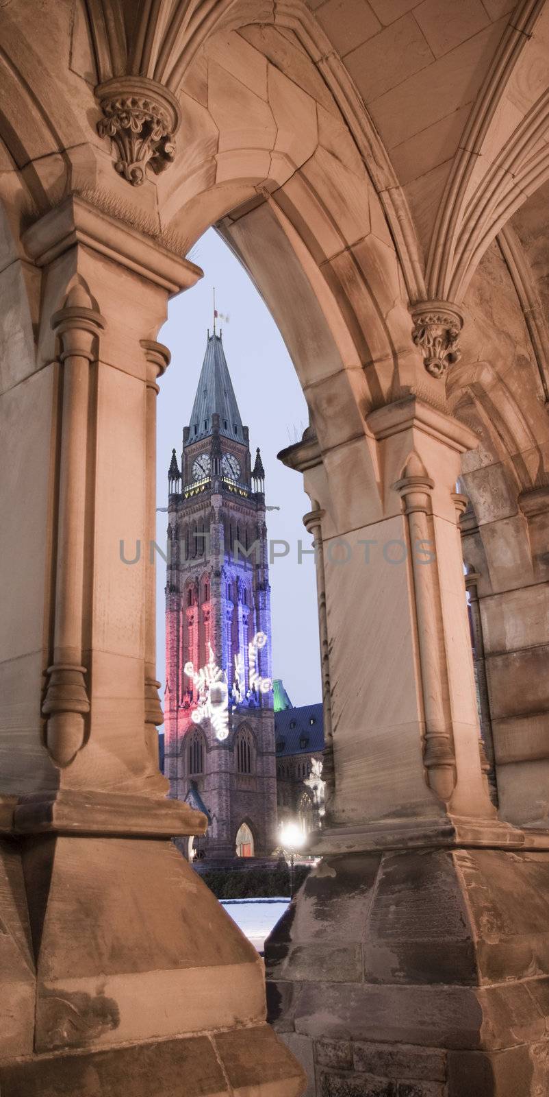 The canadian Parliament Centre Block seen through the arch of the East Block building during the Holiday Season.