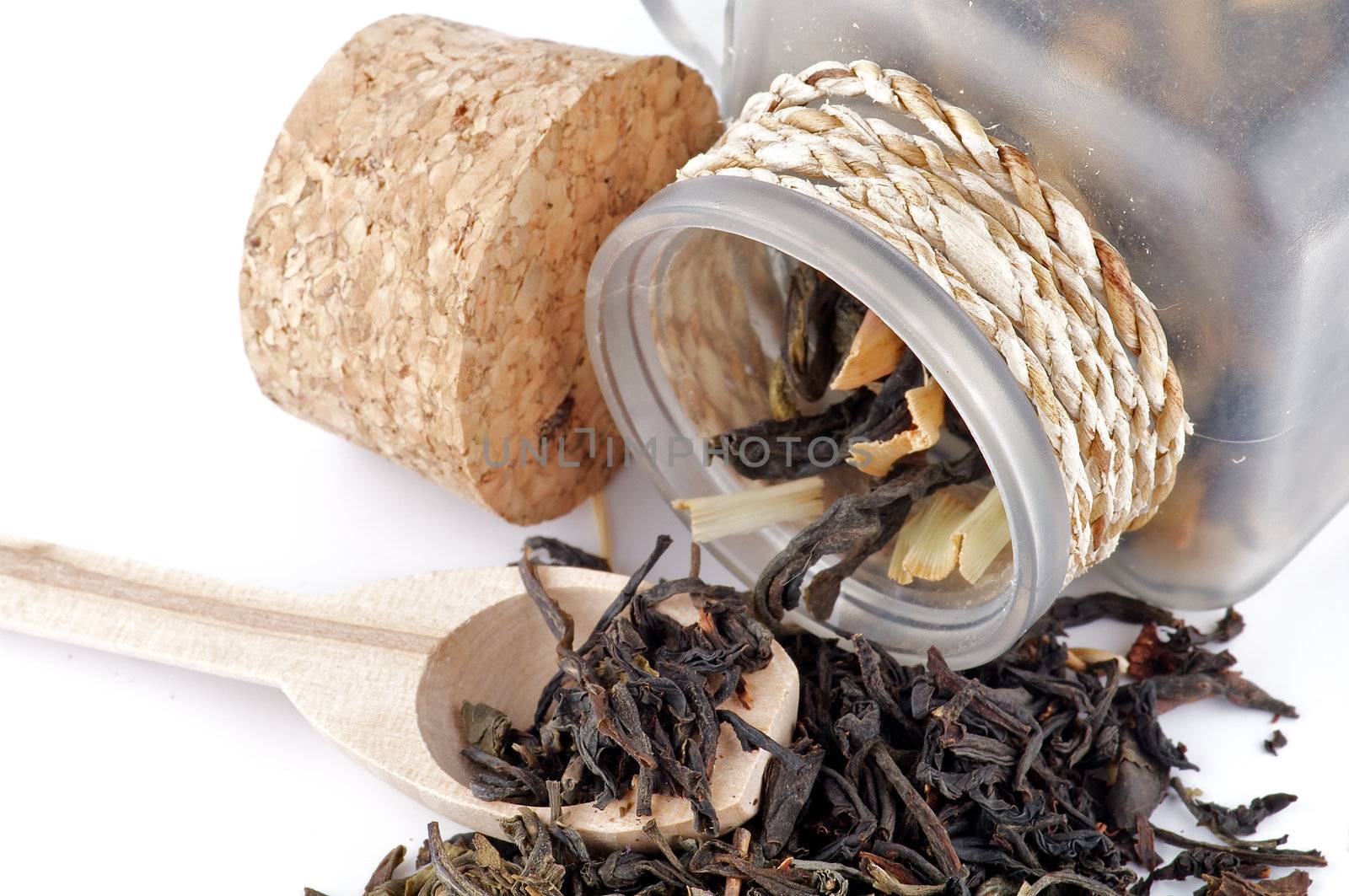 Tea leaves in transparent parison with wooden spoon by zhekos