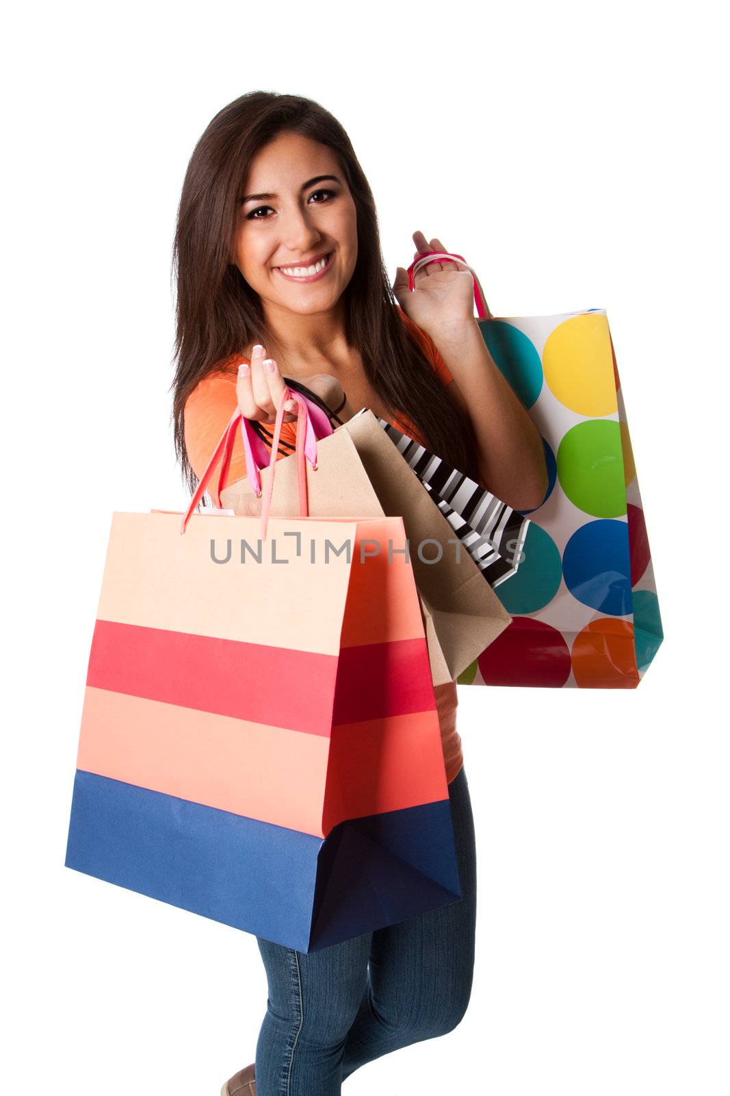 Beautiful Happy smiling young woman on shopping spree carrying colorful bags with merchandise, isolated.