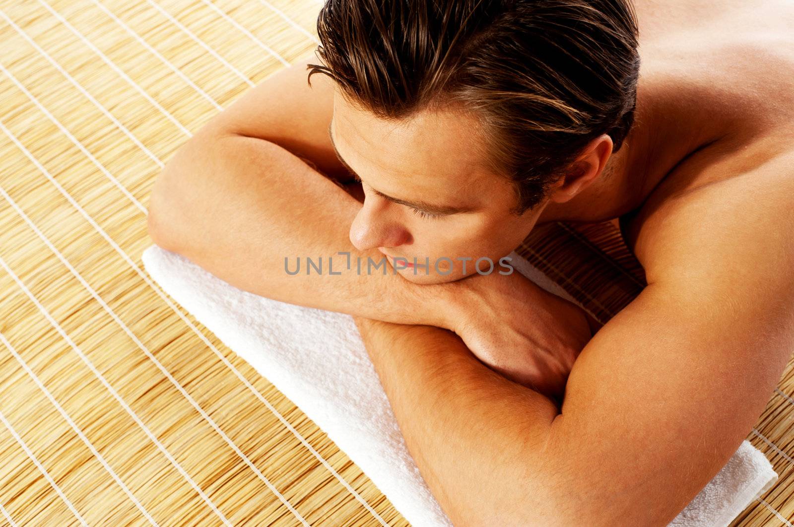 Man relaxing in a spa resort on mat by stockyimages