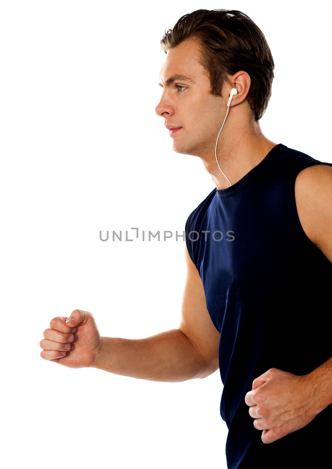 Fit athlete enjoying music in a jogging posture wearing sporty outfit