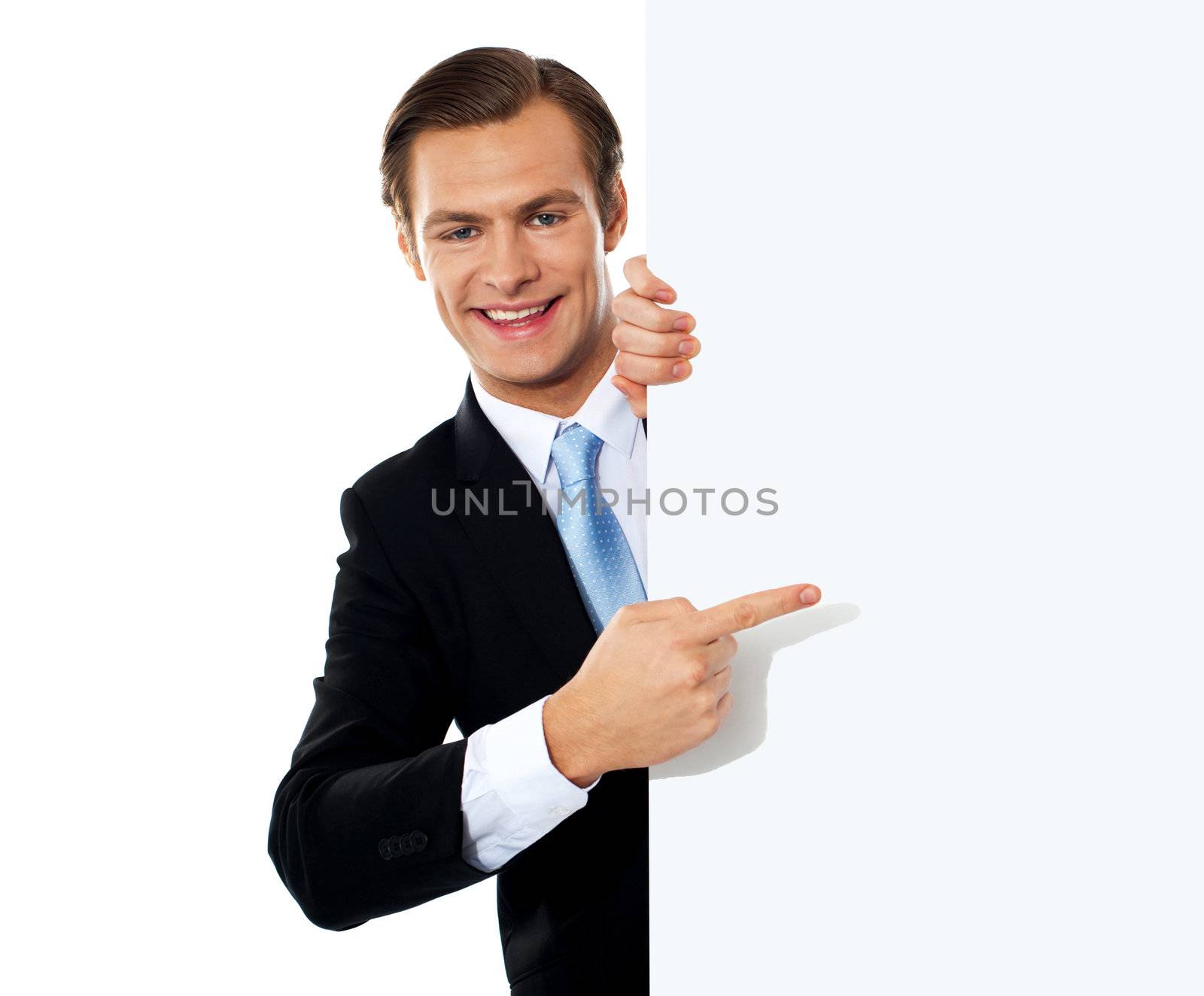 Business person pointing towards blank signboard by stockyimages
