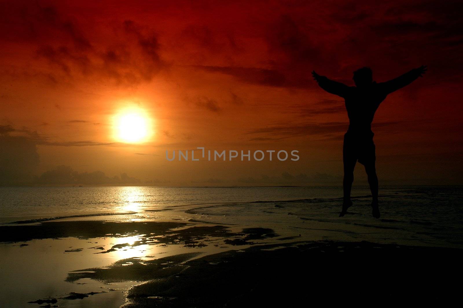 silhouette of a man jumping into the sun photographed by adding a filter gradation