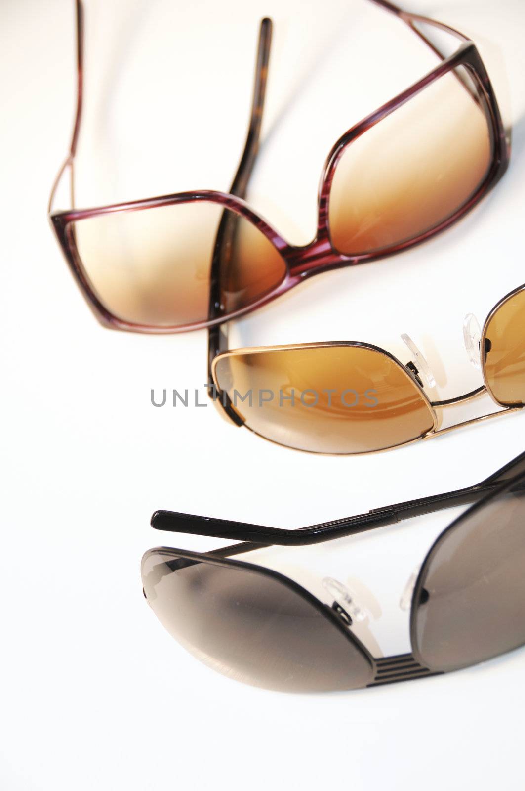 Detail of three sunglasses isolated on white