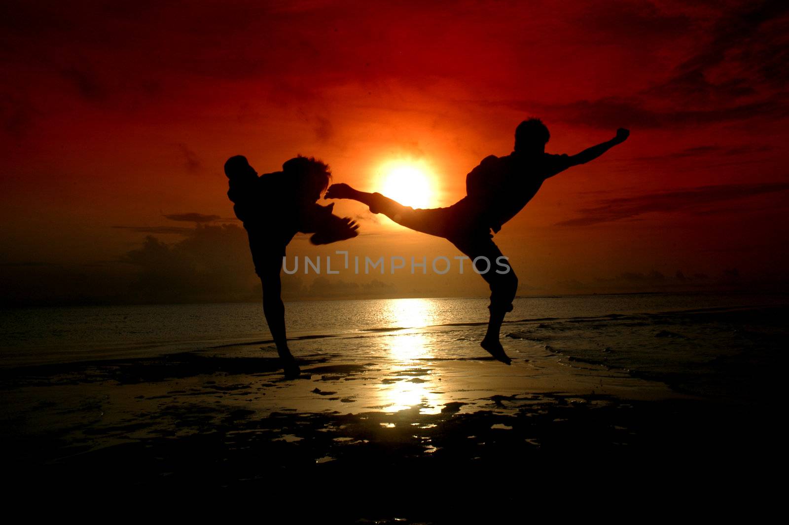 silhouette of two people who are fighting photographed before sunrise