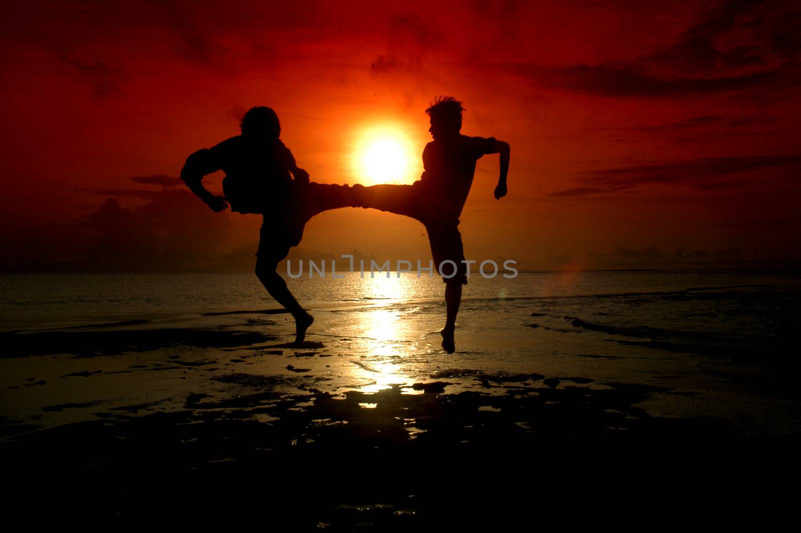 silhouette of two people who are fighting photographed before sunrise                              