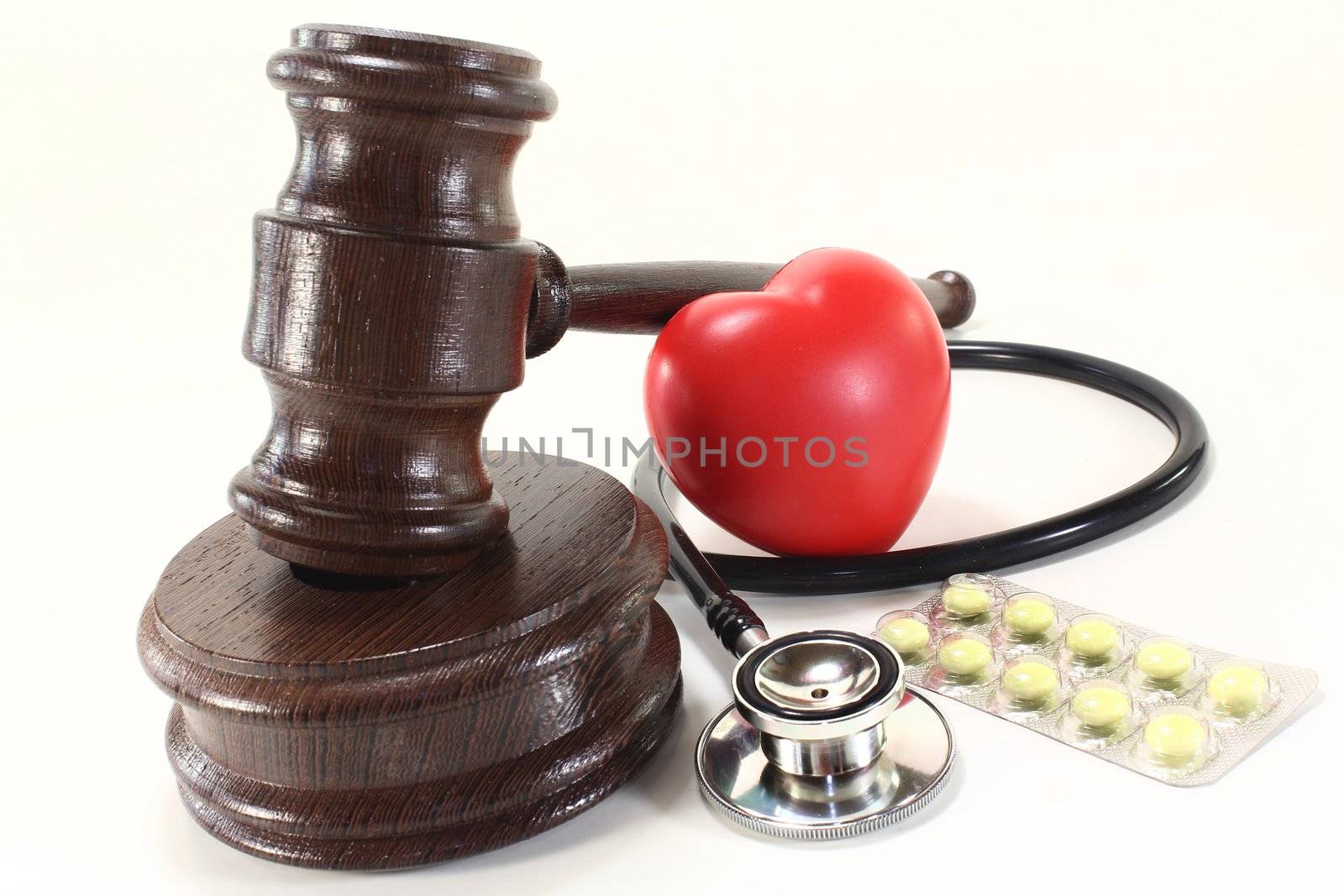 judges gavel with stethoscope and pills