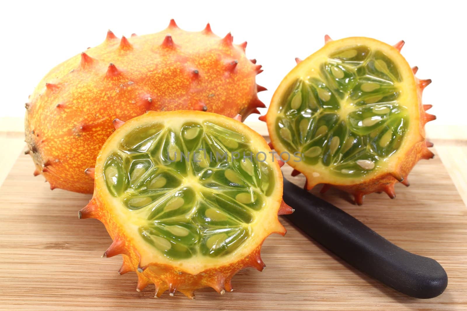 fresh sliced orange Kiwano on a wooden board