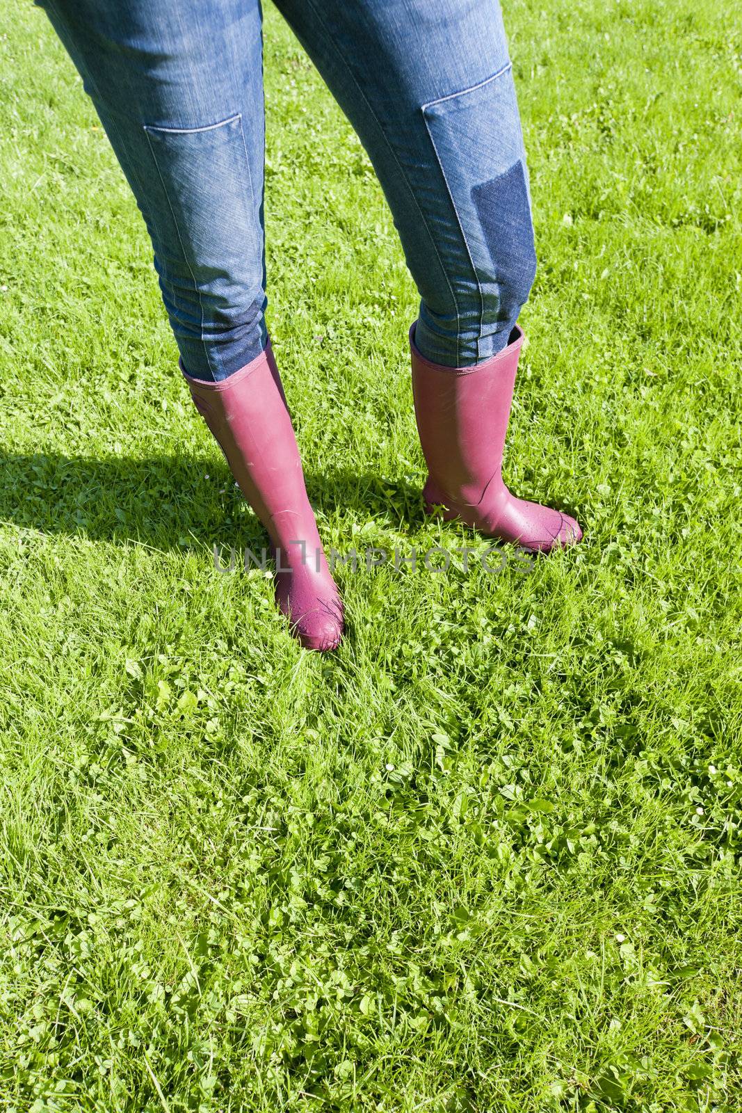 detail of woman wearing rubber boots on lawn by phbcz