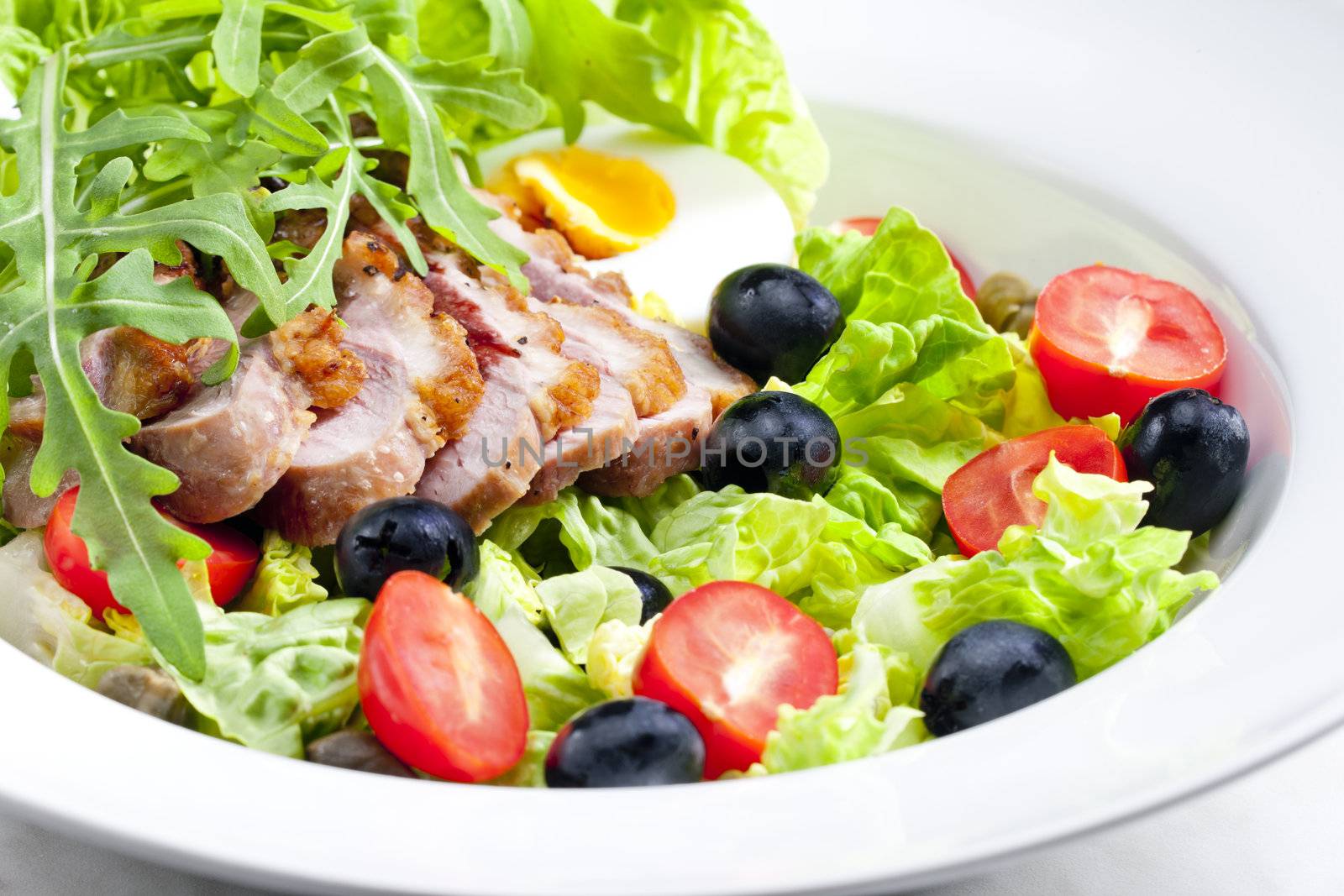 vegetable salad with fried duck breast slices and egg