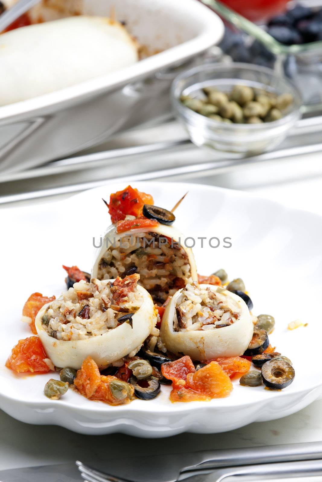 baked sepia with tomatoes and black olives filled with pearl barley risotto