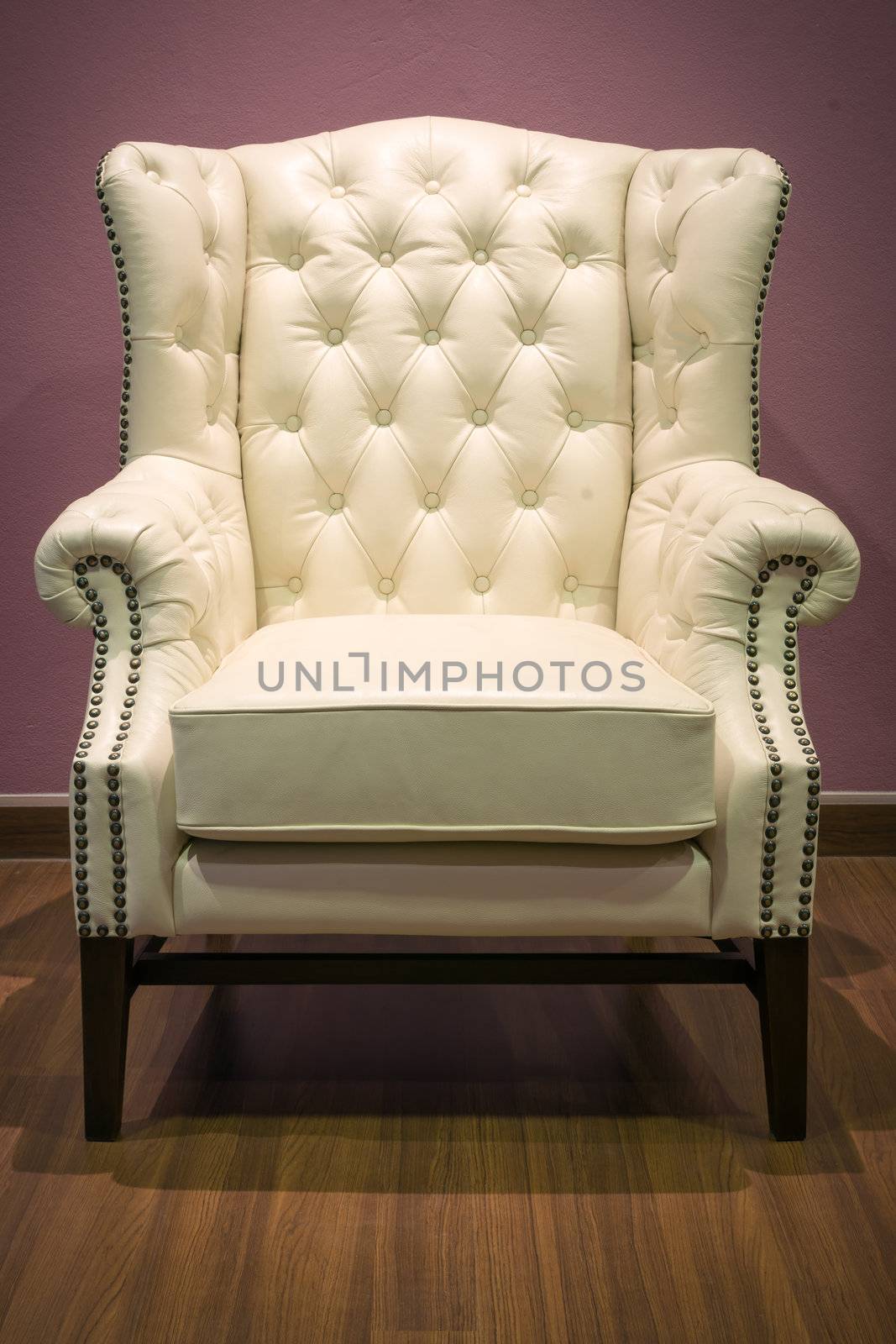 Front of Classic Chesterfield luxury White Leather armchair on Wood floor