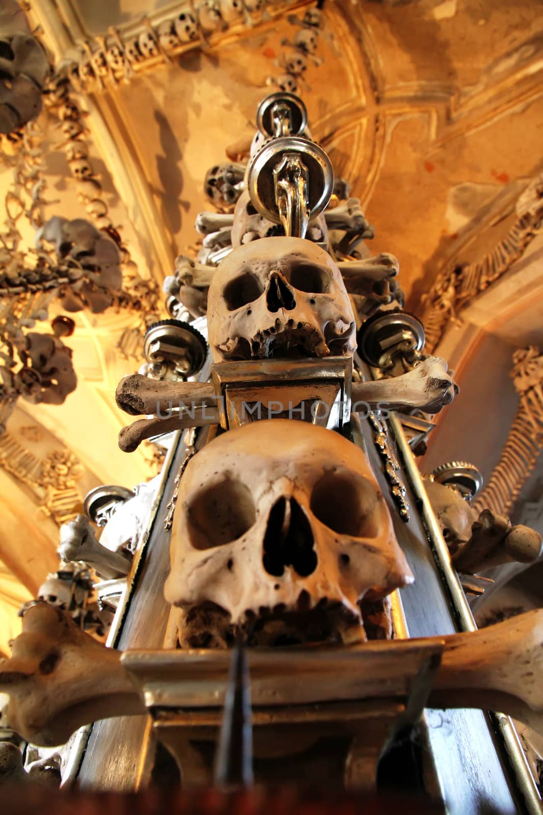 The Sedlec Ossuary is a small Roman Catholic chapel, located beneath the Cemetery Church of All Saints, in the Czech Republic. The ossuary is estimated to contain the skeletons of between 40,000 and 70,000 people, many of whom have had their bones artistically arranged to form decorations and furnishings for the chapel. The ossuary is among the most visited tourist attractions of the Czech Republic, attracting over 200 thousand visitors yearly.