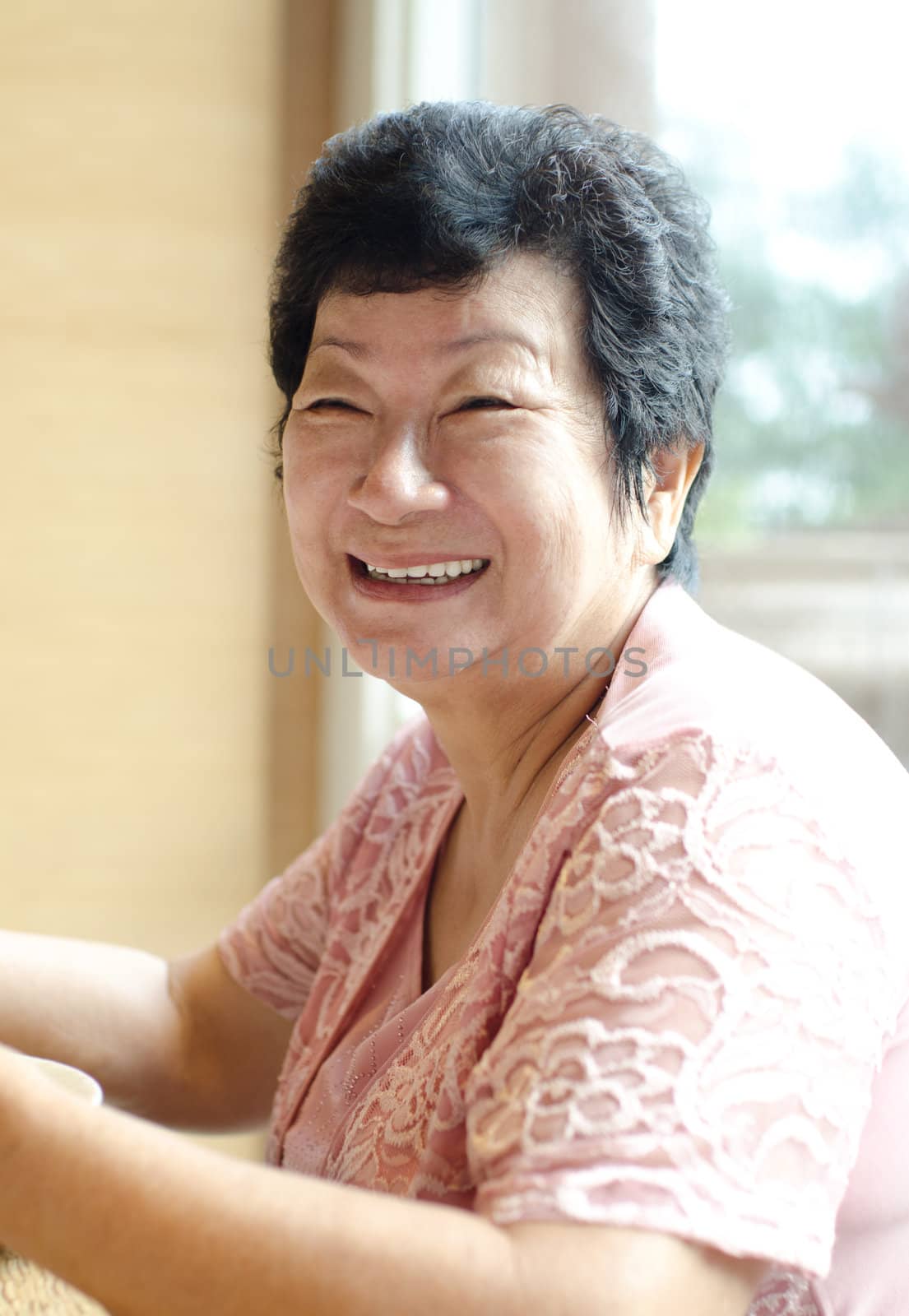 Happy 60s Senior Asian Woman dining indoors