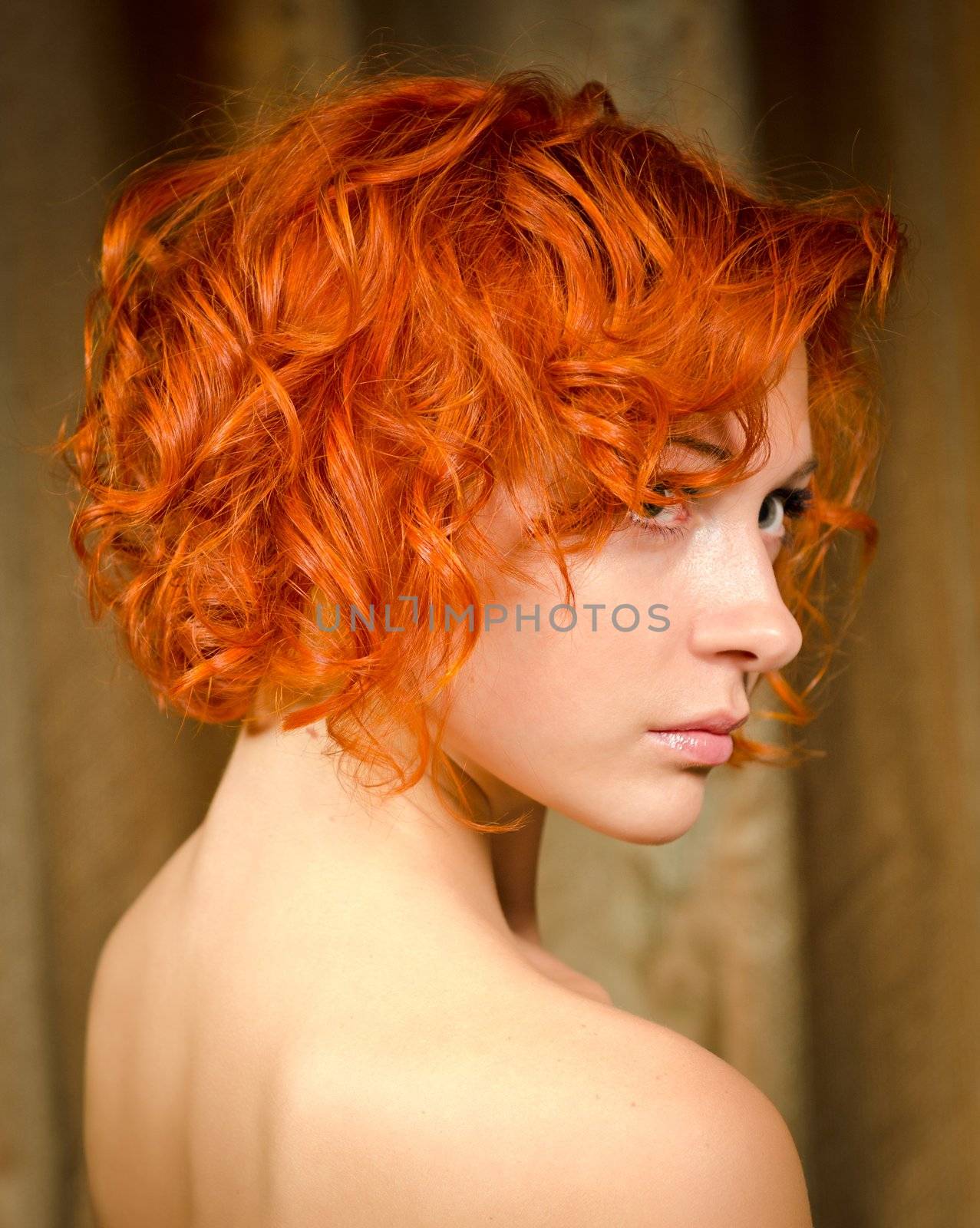 Beautiful curly red woman with bare shoulders