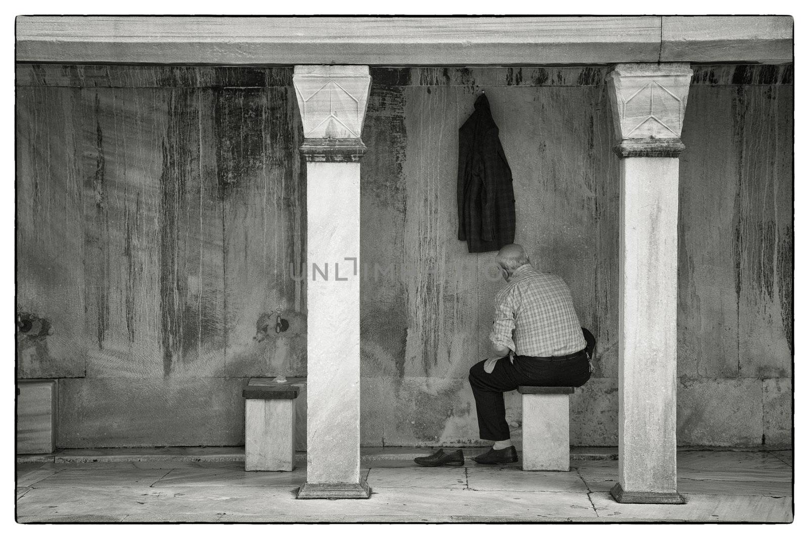 Muslim man washing his feet, hands and face before the prayer in the Sulthanahmet Mosque, Istanbul, Turkey.The mosque is a masterpiece built with the understanding of architect Sinan in the 17th century.