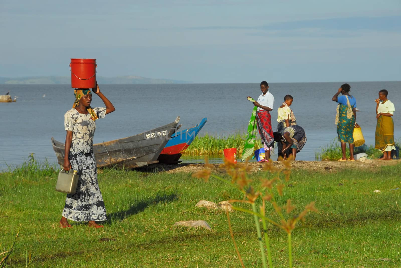 Mwanza,Tanzania-7 June, 2010:Women on the shore of Lake Victoria. Women wash their clothes in the lake and load the containers on their heads