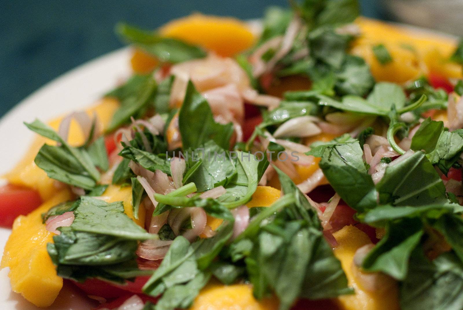 Green salad served with mango and tomatoes