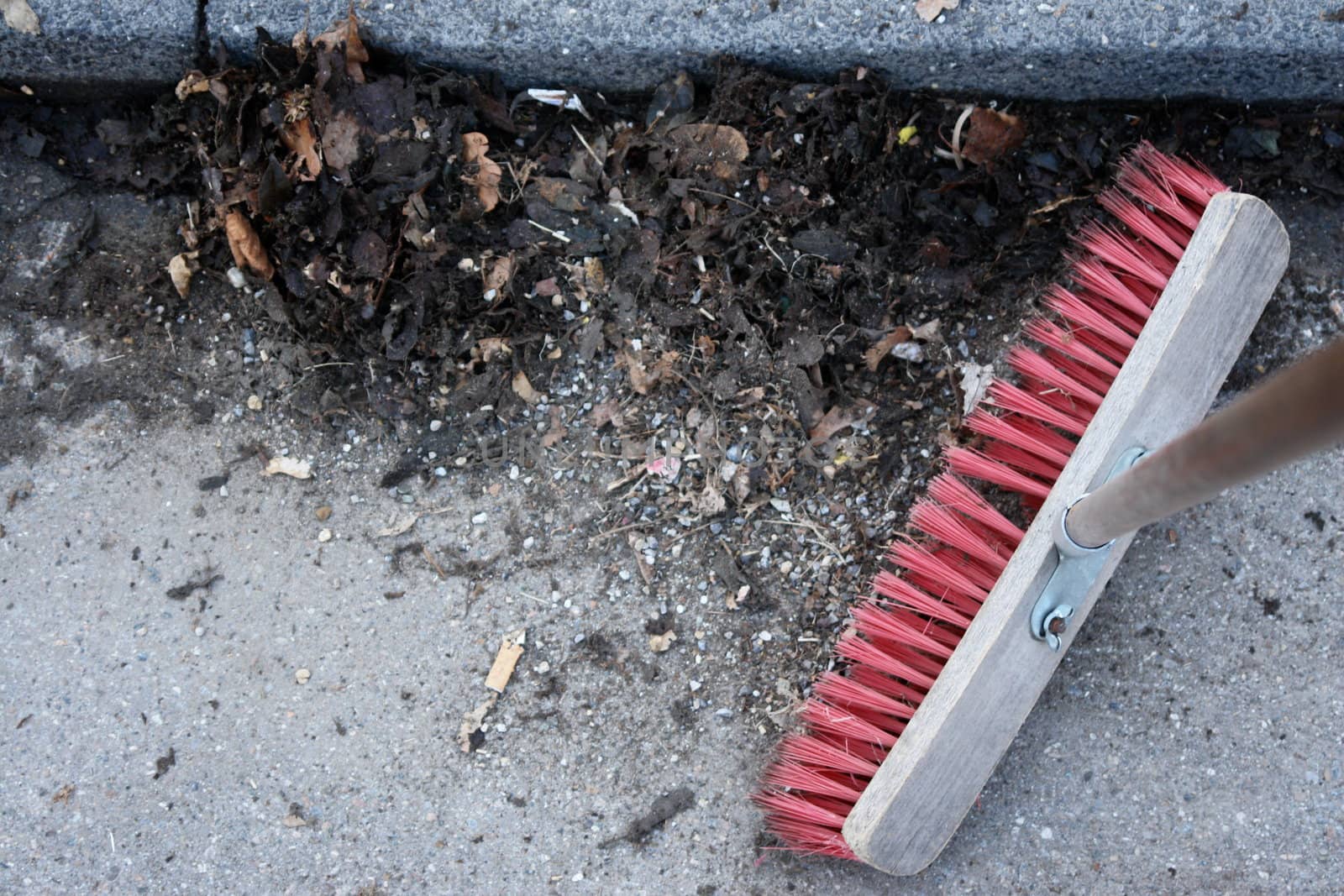 sweeping the sidewalk with a broom