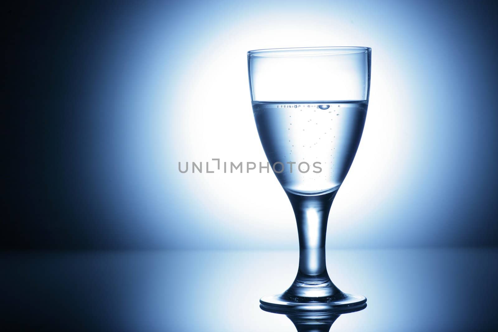 water glass on reflecting ground shimmering blue