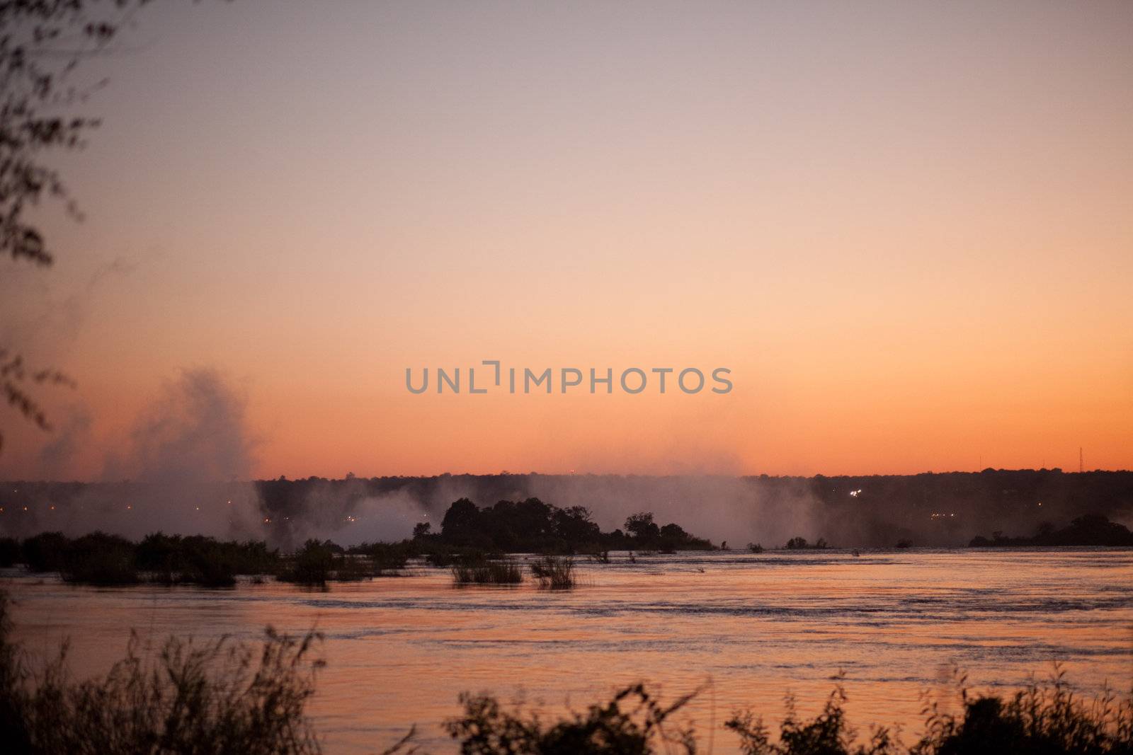 Plume of mist rising from Victoria Falls at sunset