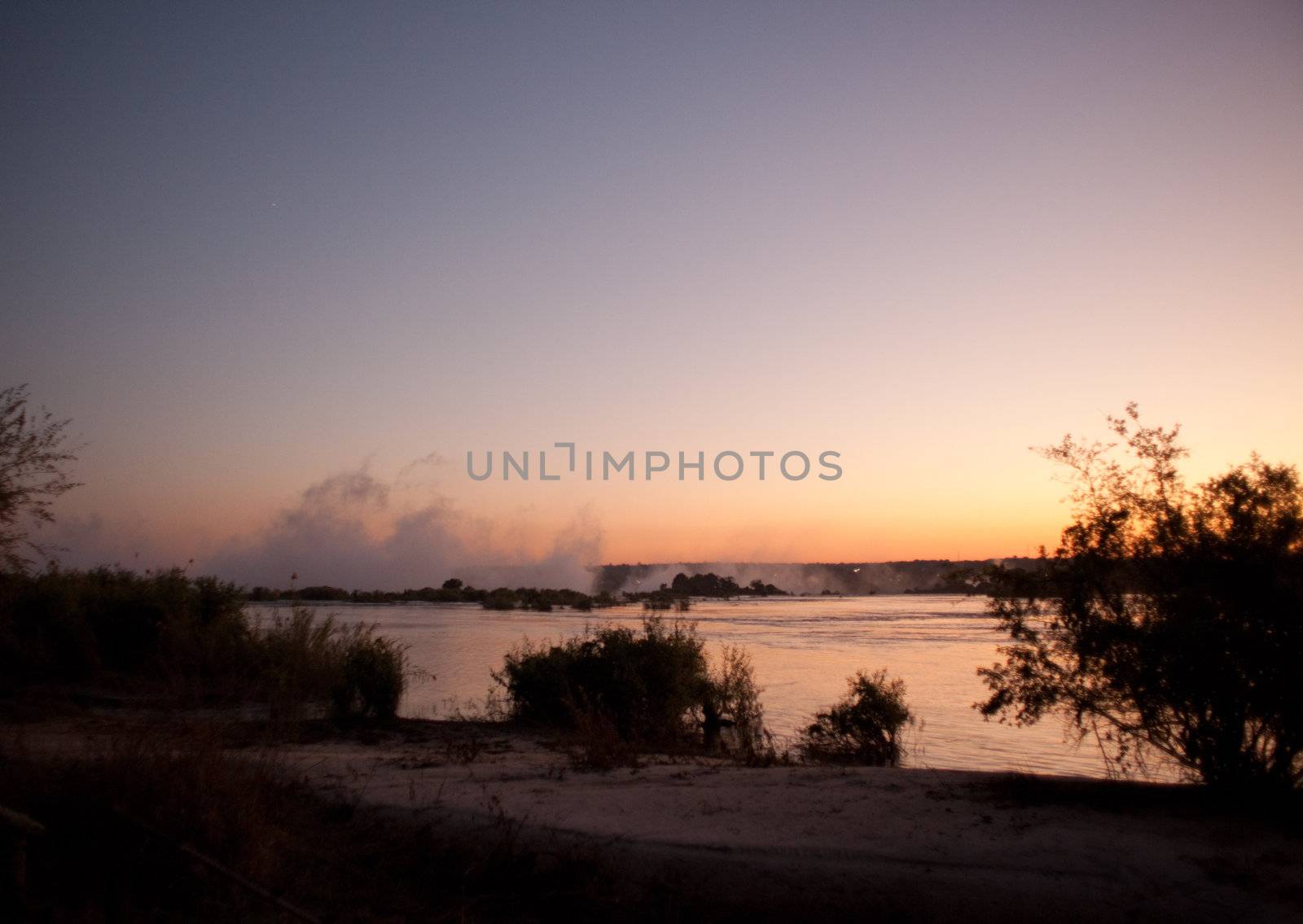 Plume of mist rising from Victoria Falls at sunset