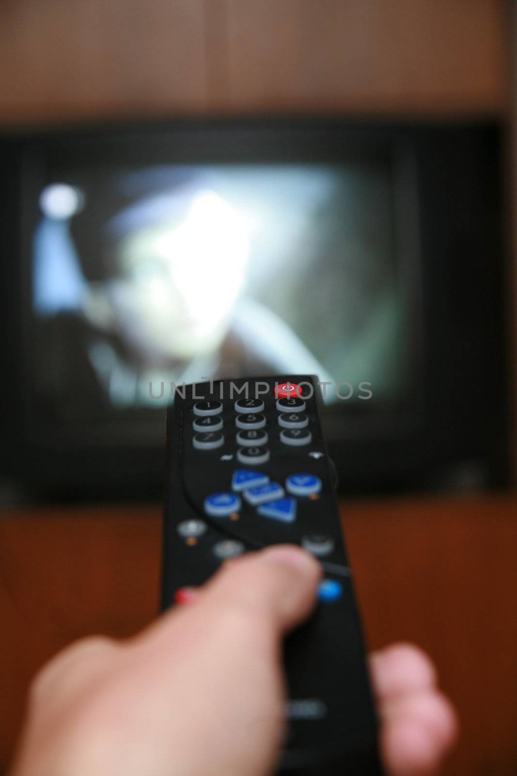 a remote control pointing to a tv.