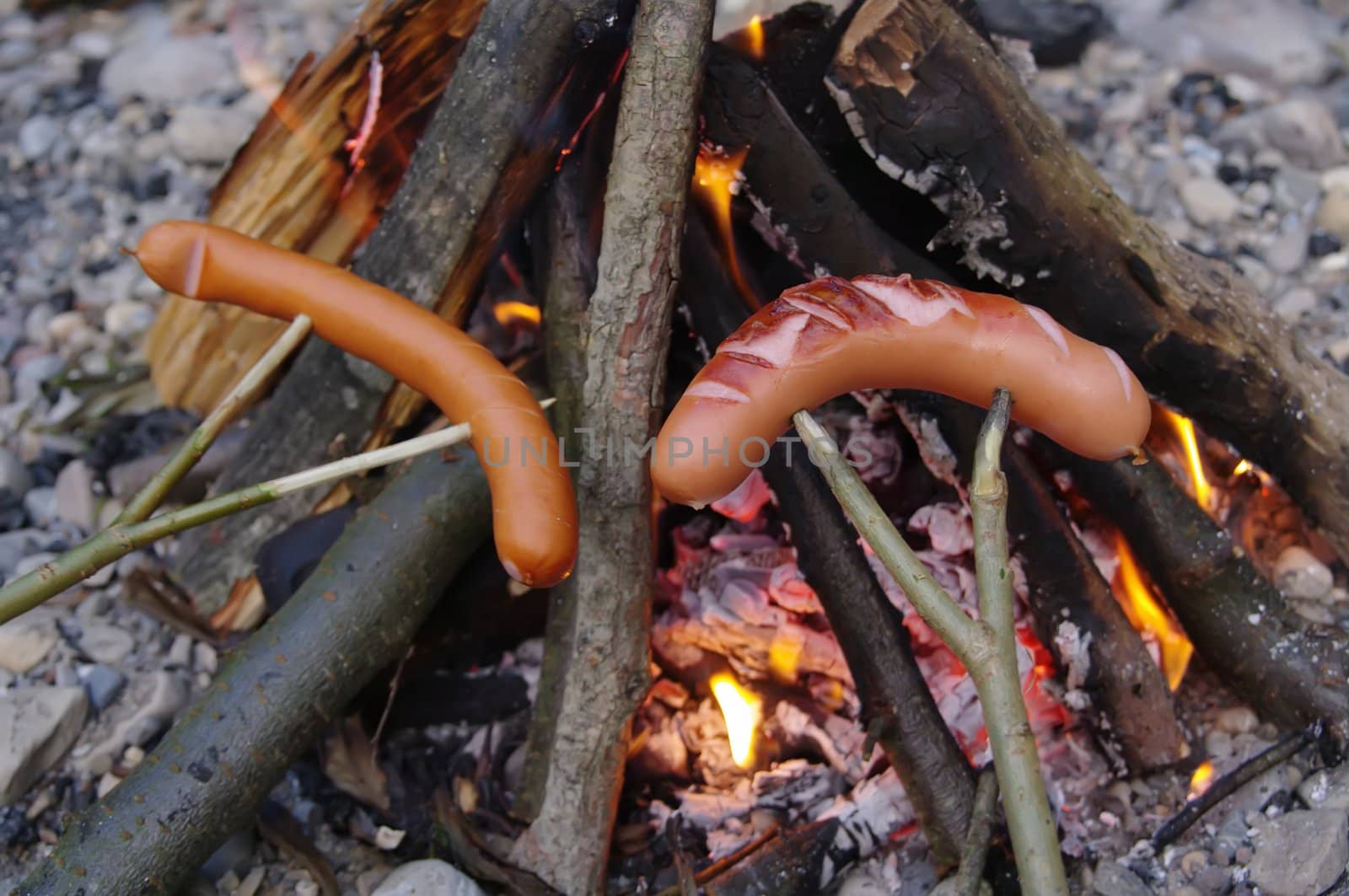 a sausage grilled on a camp fire