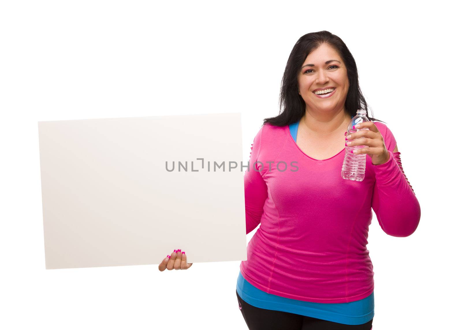 Attractive Middle Aged Hispanic Woman In Workout Clothes with Water Bottle and Blank White Sign Against a White Background.