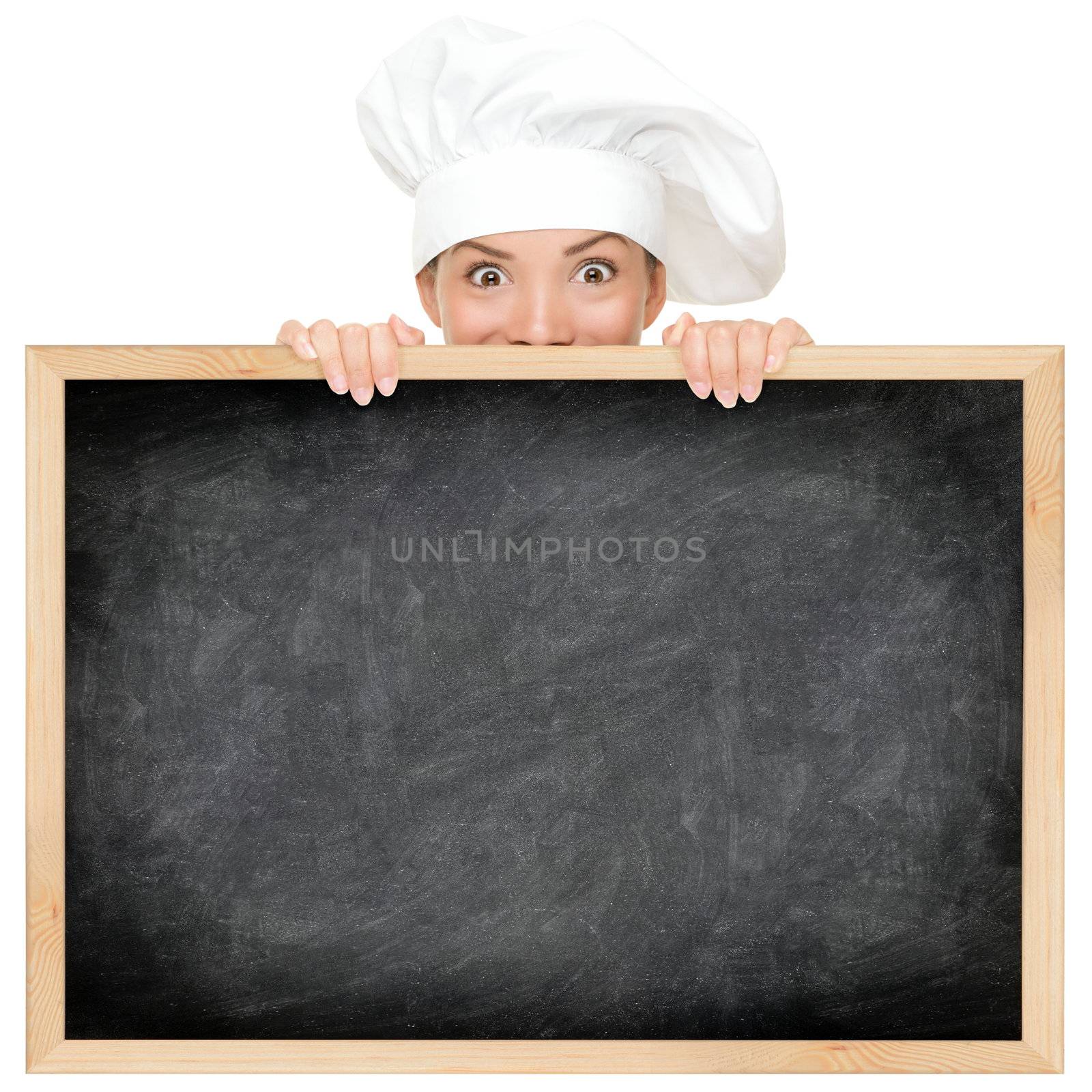 Chef showing restaurant menu blackboard - empty blank with copy space for text etc. Funny woman cook peeking over sign. Beautiful happy smiling mixed race Caucasian / Asian female model. Isolated on white background.