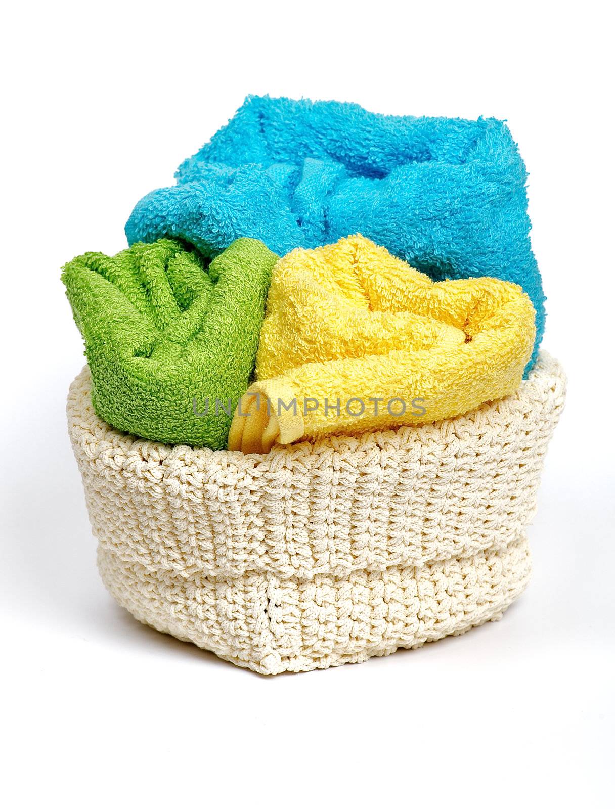 Multi-colored Terry towels in wattled container isolated on white background