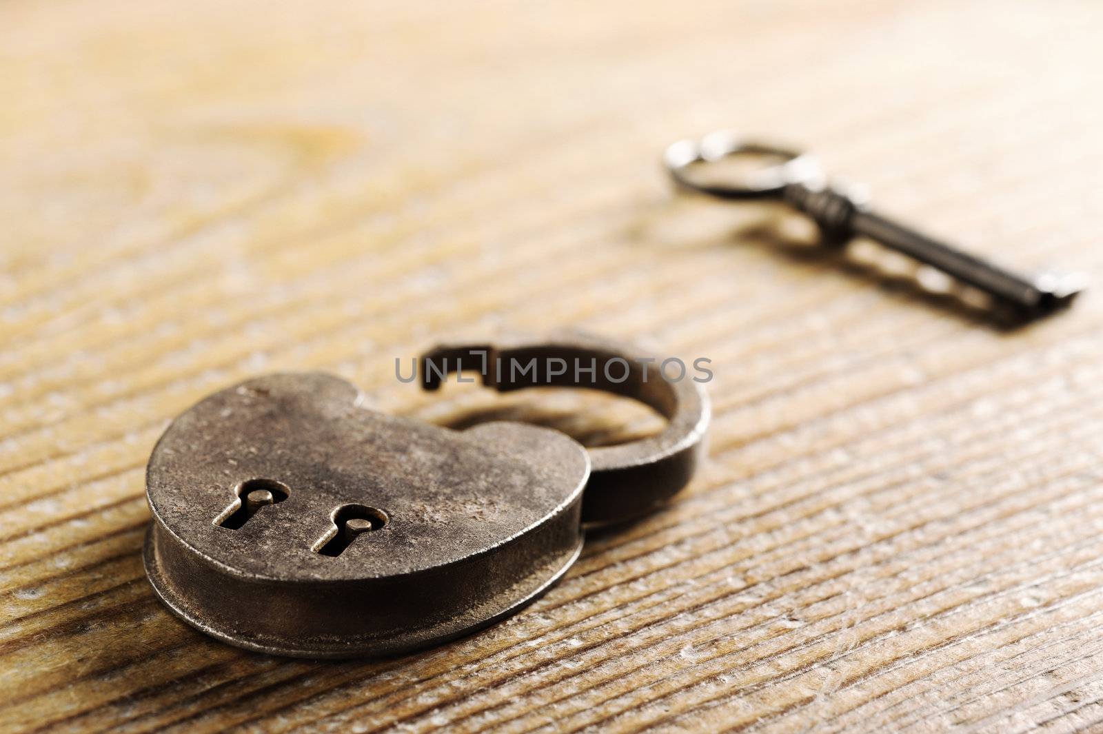 Antique Padlock with key on wooden table
