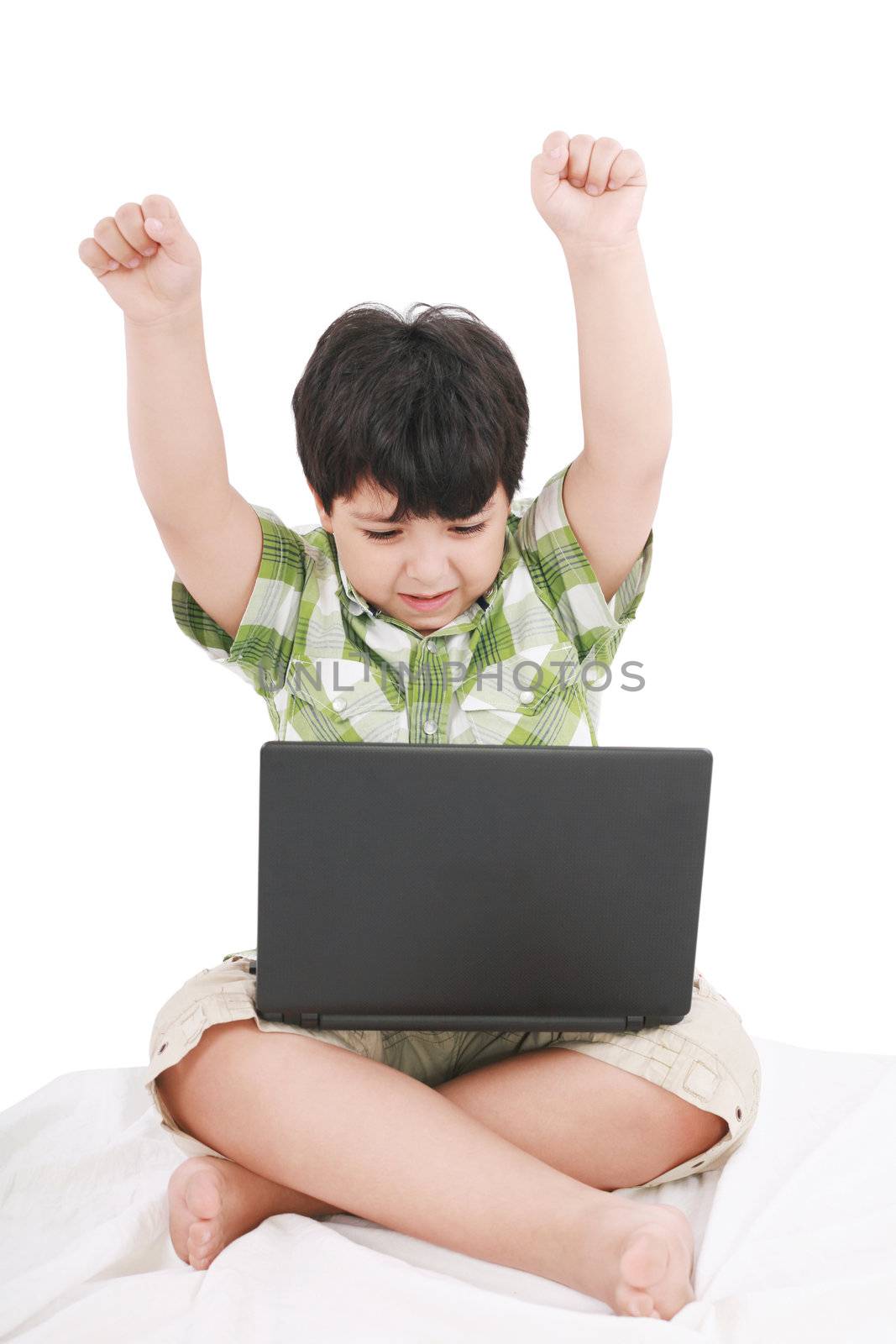 cute little boy with laptop in his bed on white by dacasdo