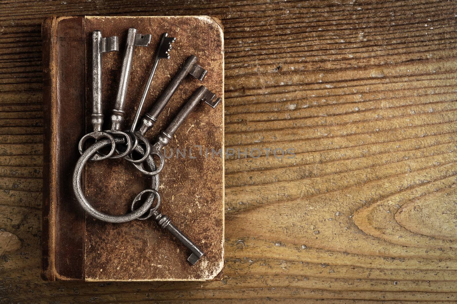 old keys on a old book, antique wood background by stokkete
