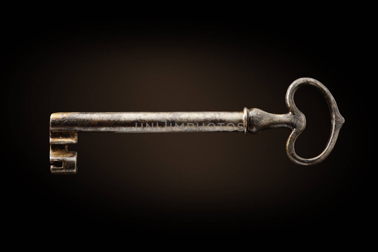 old key on dark background by stokkete