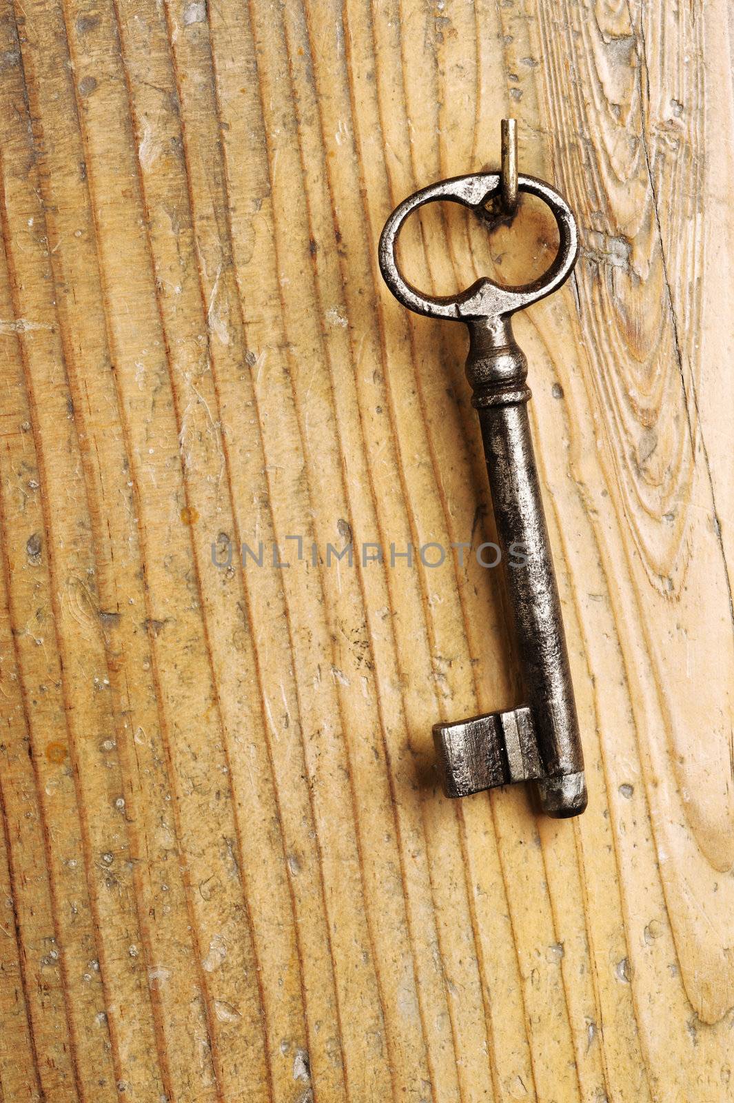 old key on a wooden background by stokkete