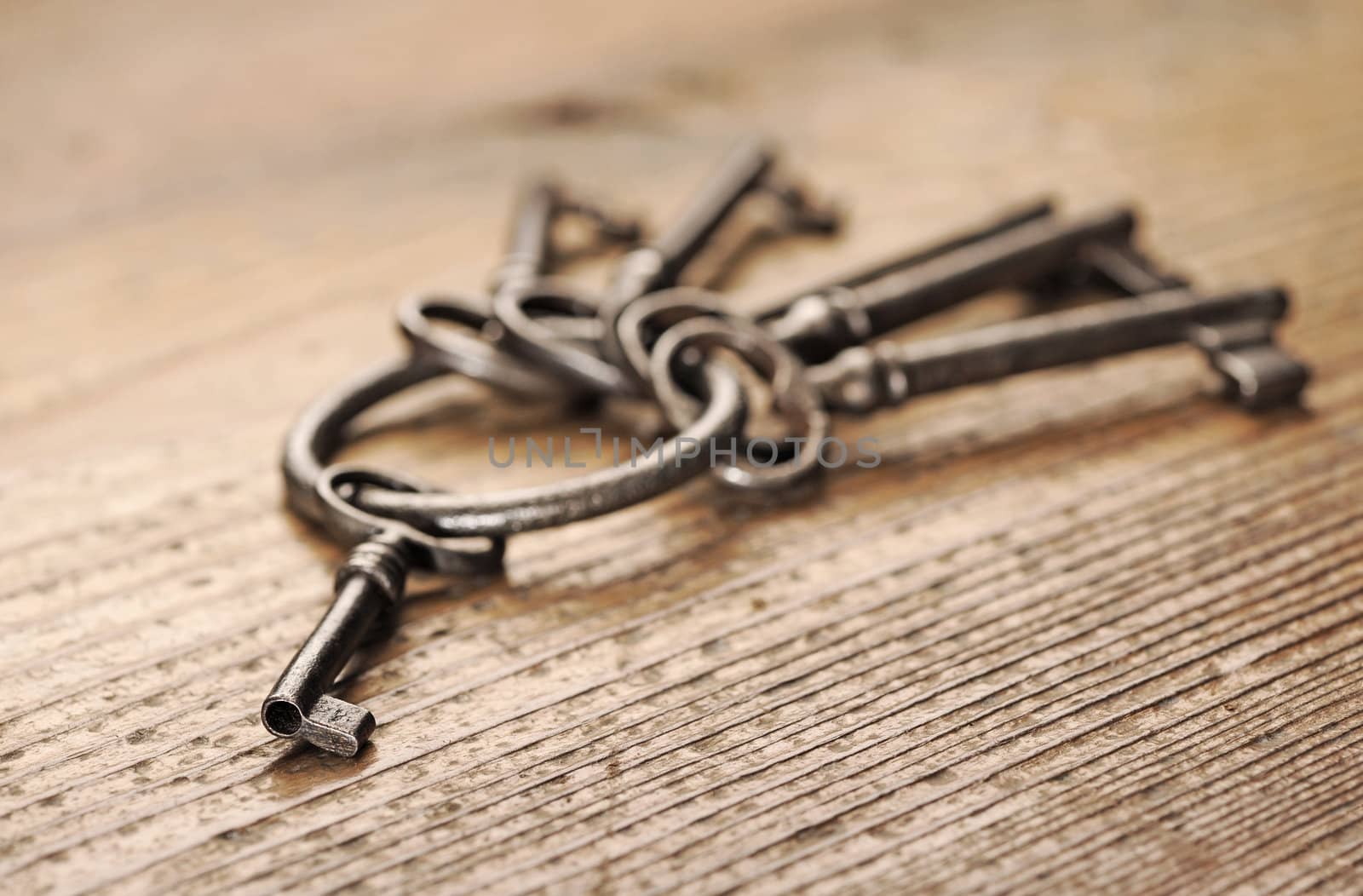 old keys on a wooden table, close-up by stokkete