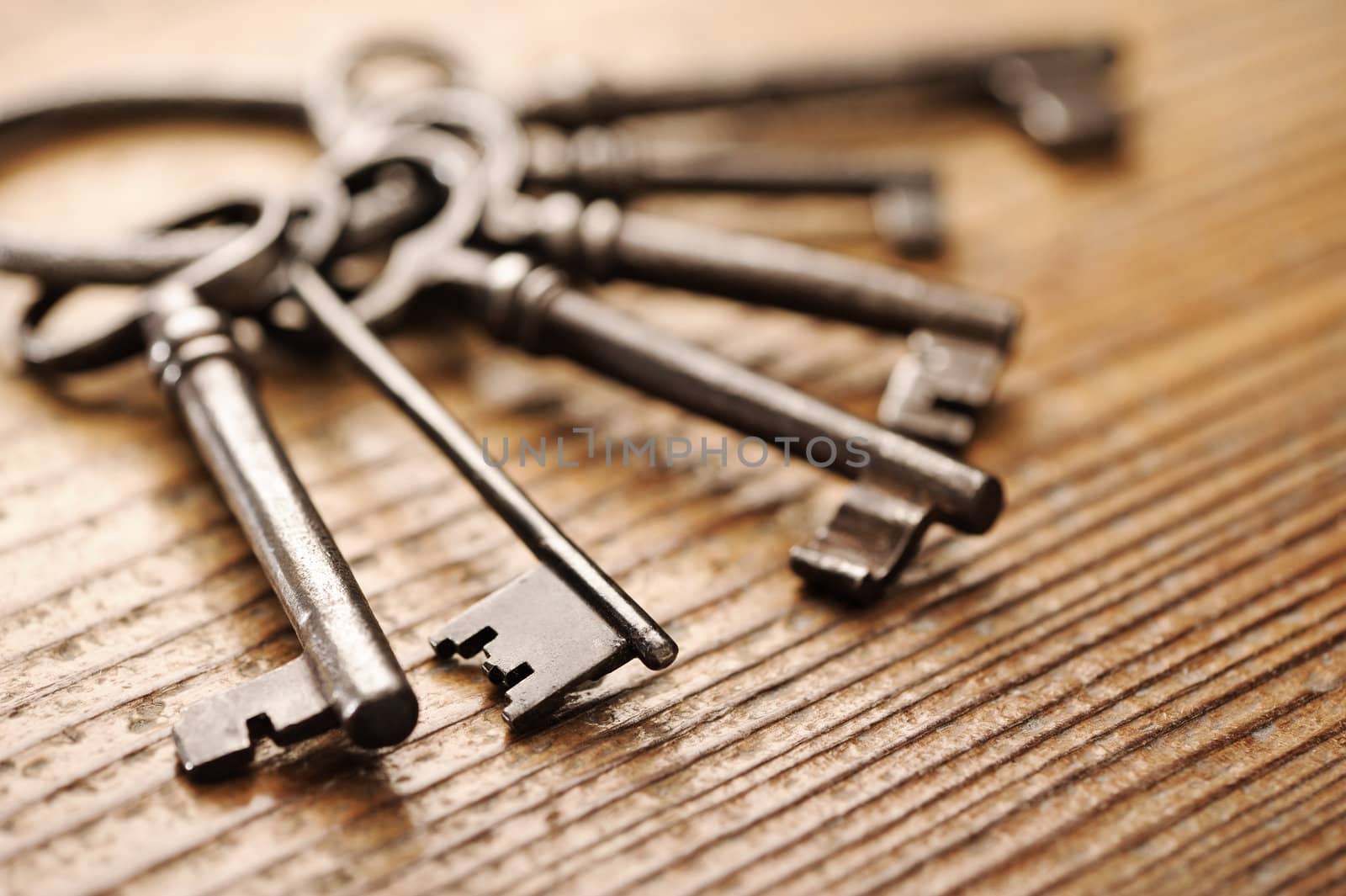 old keys on a wooden table, close-up by stokkete