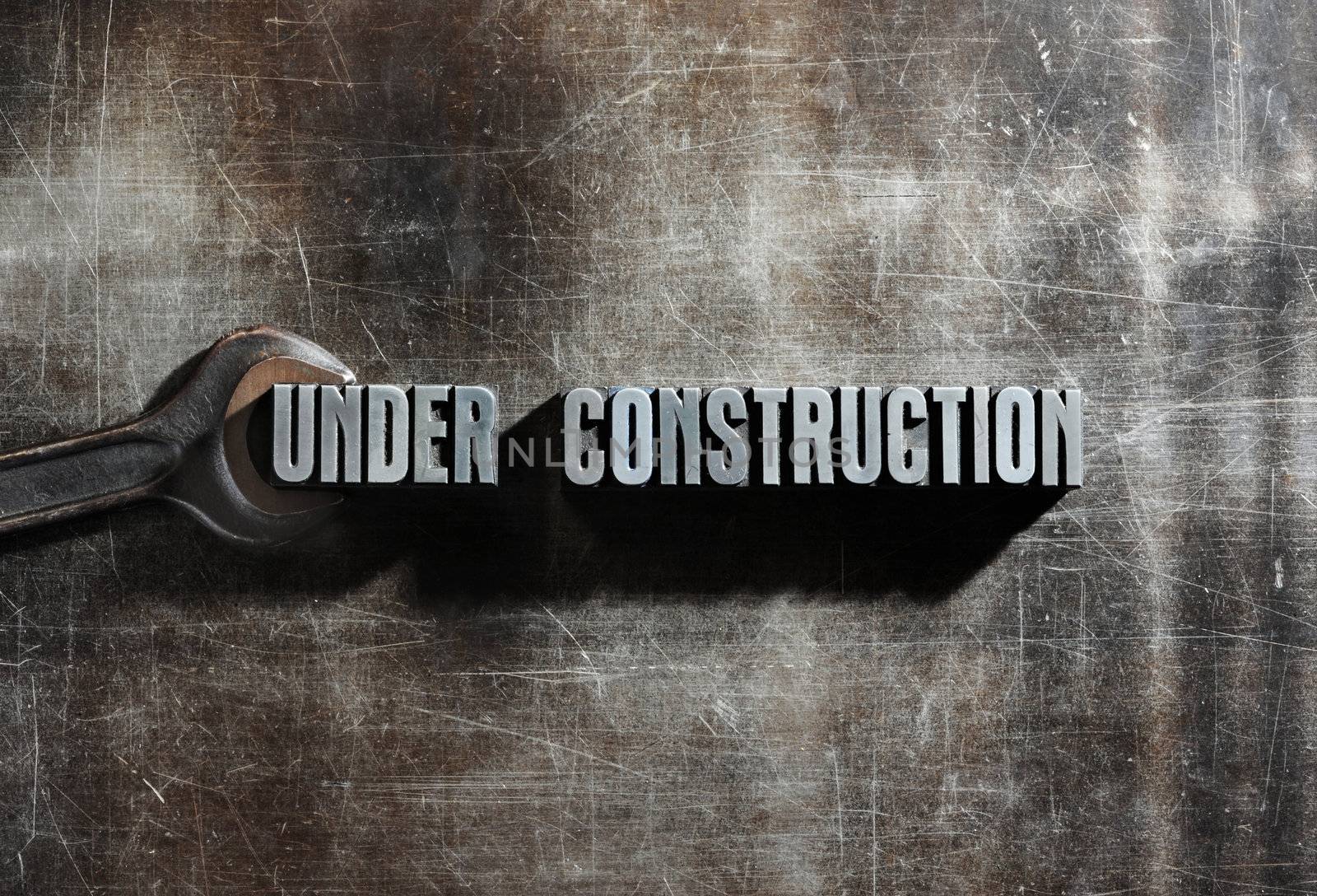 Image of a Under Construction sign with a metallic background te by stokkete
