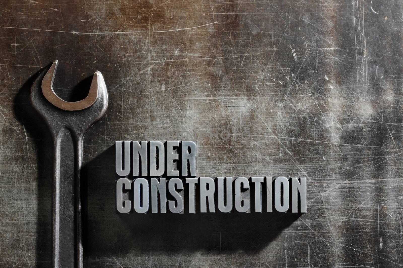 Image of a Under Construction sign with a metallic background te by stokkete