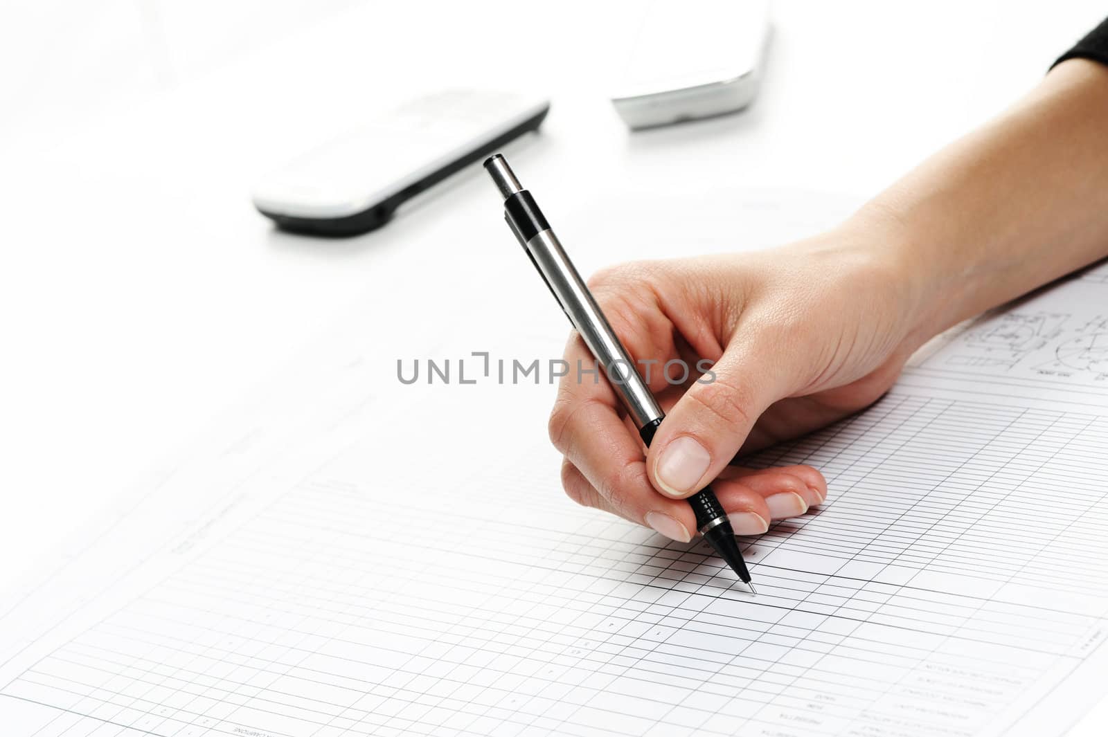 woman hand writing, cell phone on the background