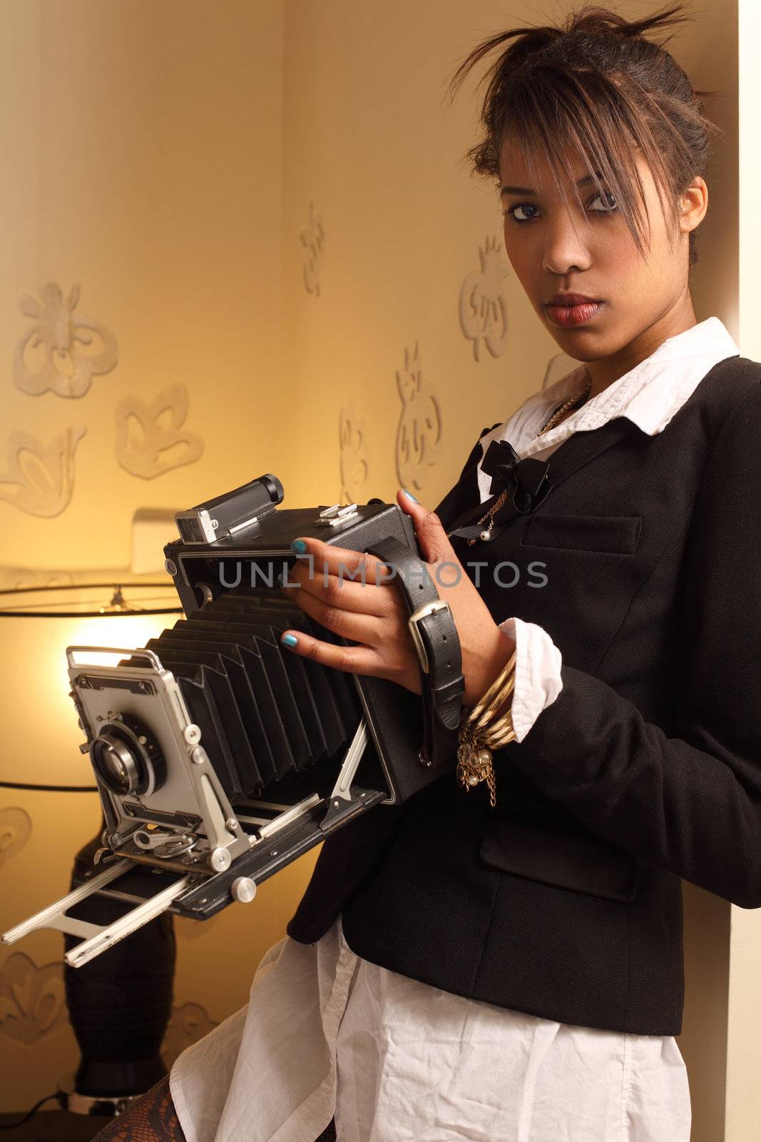Photo of a beautiful young woman of African descent, holding a vintage 4x6 film camera.