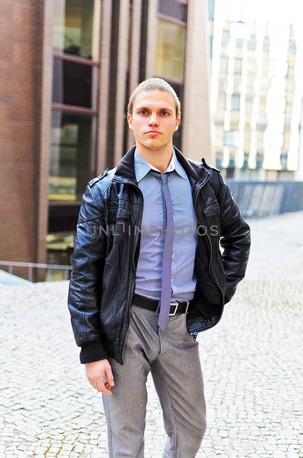 Portrait of successful young guy against urban background