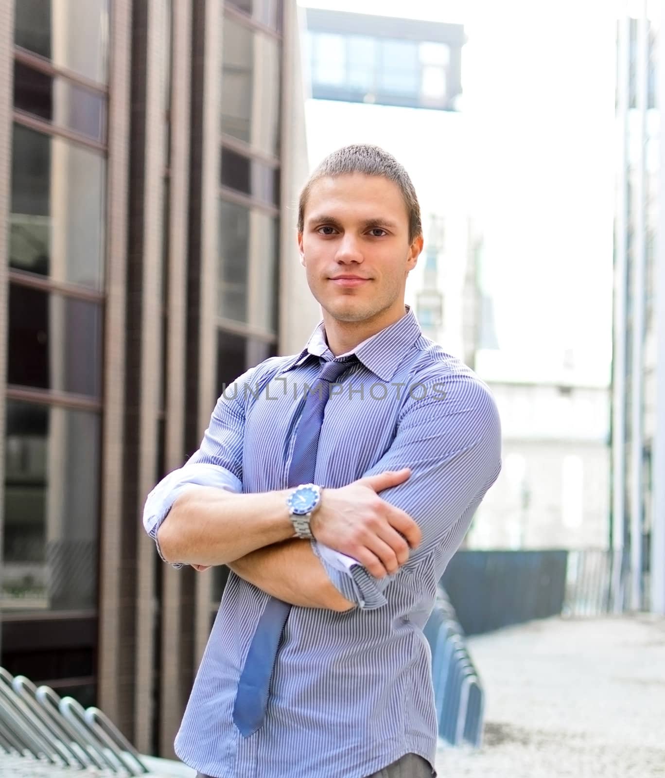 Successful man with arms folded against city backdrop