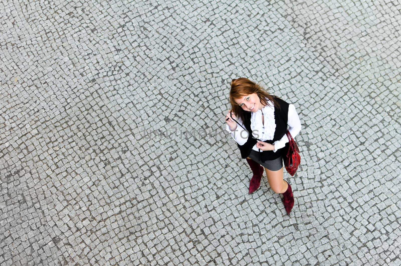 Portrait of pretty girl on the stone pavement. View from the top.